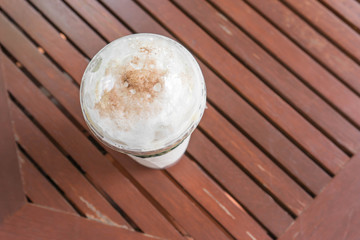 plastic cup of ice cappuccino on wooden table