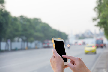 Man use mobile phone waiting for the bus with blurred Traffic ba