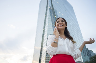 Hispanic businesswoman talking on cell phone outdoors