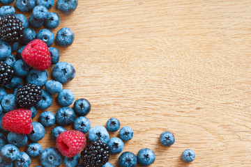 Assortment berries blueberries, raspberries and blackberries on wooden table. Close up, top view, high resolution product. Harvest Concept
