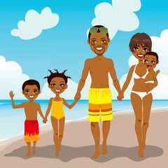 Happy African American family enjoying beach vacation walking on shore sand