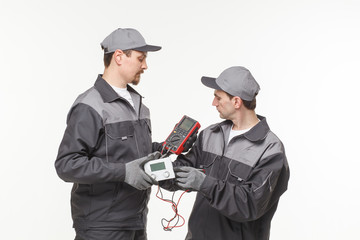 Electrician checking socket voltage with digital multimeter