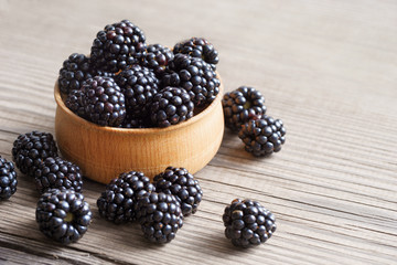Blackberries in bowl on wooden background. Close up, high resolution product. Harvest Concept