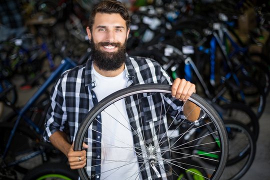 Bike mechanic holding a bicycle wheel