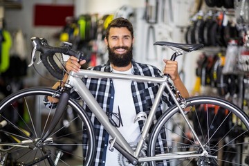 Casual hipster lifting a bicycle