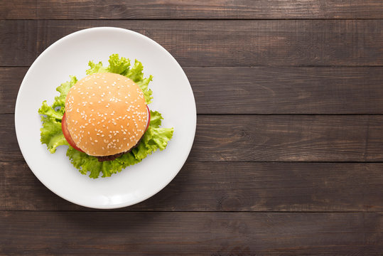 Top view BBQ burger on white dish on wooden background