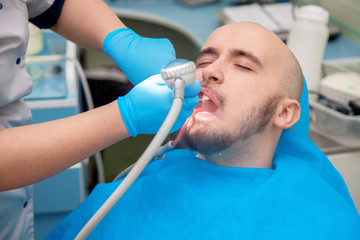 Young adult male patient takes a dental attendance in the dentis