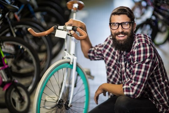Bike mechanic crouching next to a bicycle