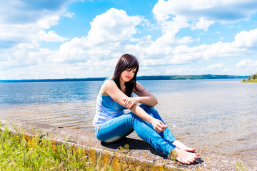 Fototapeta na wymiar Beautiful girl relaxing near the river