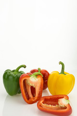 Fresh bell peppers, one cut in half, isolated on white background with copy-space