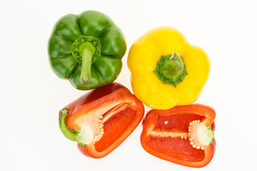 Fresh green, yellow and cut in two red bell peppers, isolated on white background.