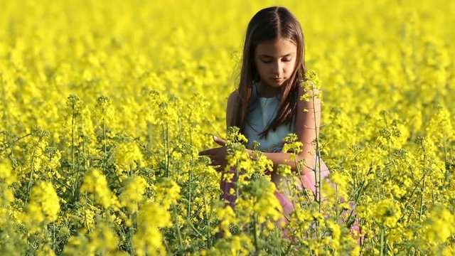 Happy Beauty young girl playing in yellow rape field in rural countryside. Portrait shot, Happy Freedom outdoors concept.