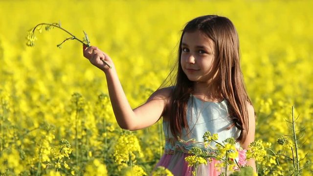 Happy Beauty young girl playing in yellow rape field in rural countryside. Portrait shot, Happy Freedom outdoors concept.
