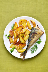 Roasted potato wedges and mackerel fish, top view