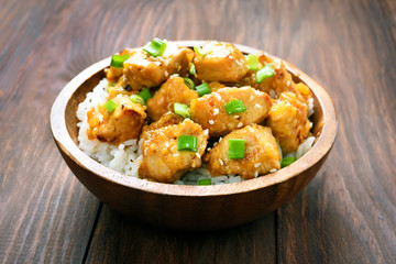 Chicken with orange sauce in wooden bowl