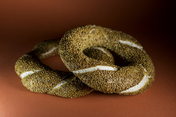 Two simit bagels against a red background