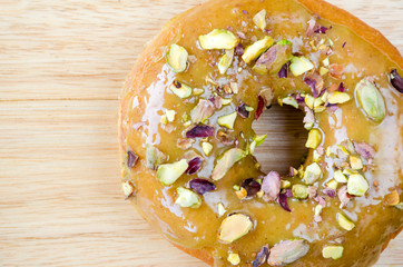 Donuts with pistachio on wooden background.