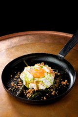 Green asparagus with poached egg in a frying pan
