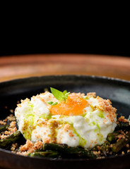 Green asparagus with poached egg in a frying pan