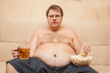fat man eating popcorn and drinking beer