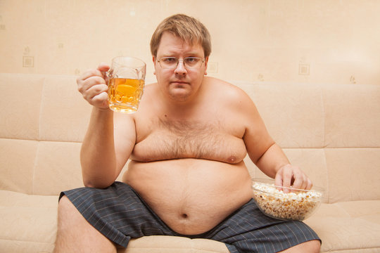 fat man eating popcorn and drinking beer