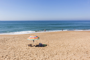 Fototapeta na wymiar Beach Ocean Umbrella swimmers