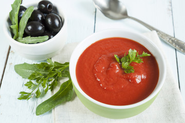Colorful tomato soup on a white background, closeup