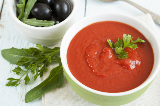 Colorful tomato soup on a white background, closeup