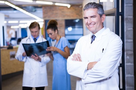 Portrait of male doctor standing with arms crossed