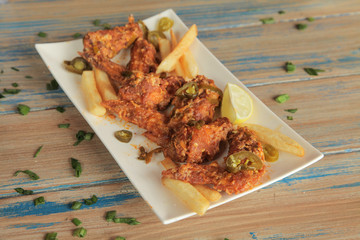 Jalapeno wings on a plate with grungy wooden background