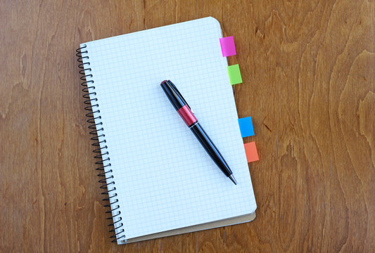 Pen and Notepad on the wooden desk