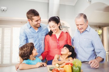 Obraz na płótnie Canvas Cheerful family standing by kitchen table