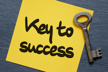 Sticky note with key to success concept