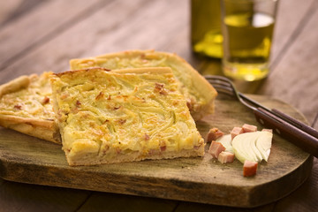 Traditional German Zwiebelkuchen or onion cake, made of a yeast dough and topped with onions and...