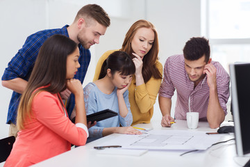 creative team with blueprint working at office