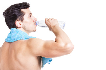 Fitness man drinking a bottle of water, isolated on white backgr