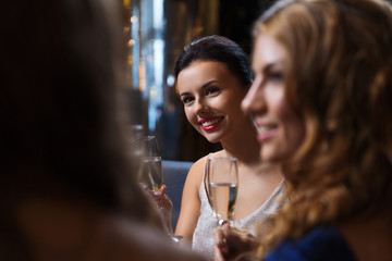 happy women with champagne glasses at night club