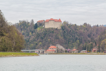 Brestanica, Slovenia - April 2, 2016. View of the Rajhenburg castle on the top of the hill by Sava river and surrounding buildings.