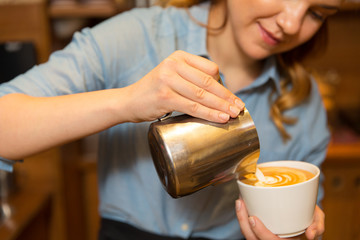 close up of woman making coffee at shop or cafe