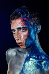 Crazy young androgyne man with face art. SPACEMAN. Freak person. Tinsel creative blue makeup....