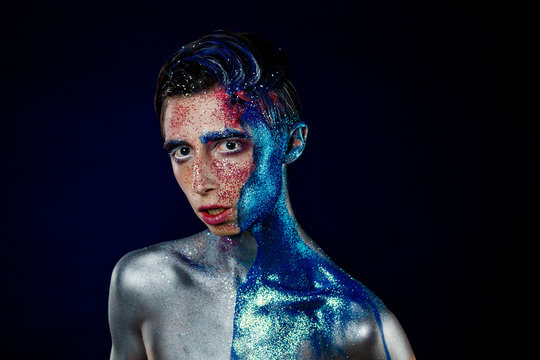 Crazy young androgyne man with face art. SPACEMAN. Freak person. Tinsel creative blue makeup. Intersex and anorexia concept. Space for logo