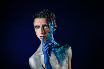 Crazy young androgyne man with face art. SPACEMAN. Freak person. Tinsel creative blue makeup. Intersex and anorexia concept. Space for logo. HOMOSEXUALITY