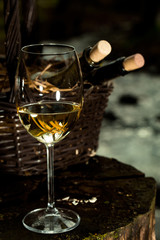 Wine glass near bottles in basket