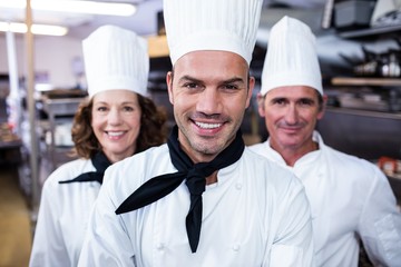Team of chefs smiling in commercial kitchen