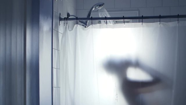 Showering Woman Silhouette Blurred by the Transparent Curtain