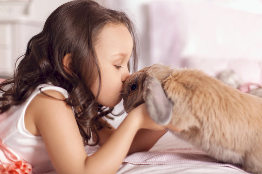 Девочка целует кролика
