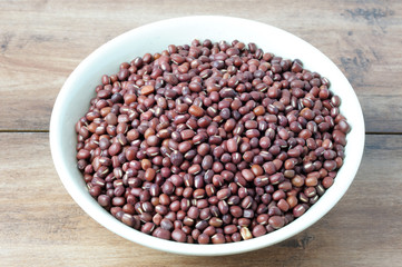 Close up of Adzuki beans on a white bowl with wooden table