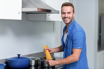 Young man cooking spaghetti