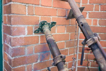 Acro supports leaning against brick wall © LoloStock