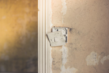Broken light switch on dirty wall